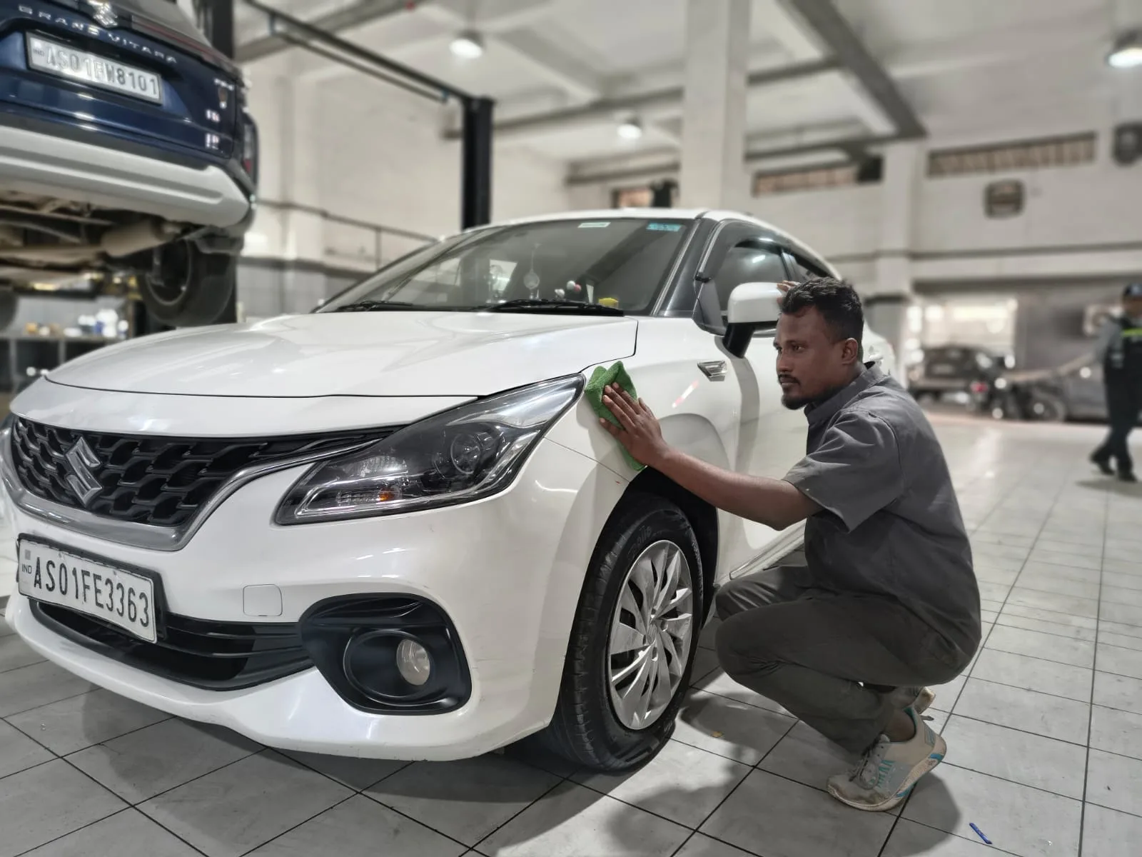 Maruti Suzuki service centre technician inspecting a vehicle